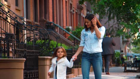 Young-mother-and-daughter-walking-down-Brooklyn-street