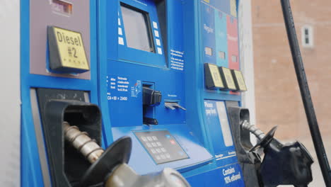 woman pays for refueling a car with a credit card in a column at a gas station