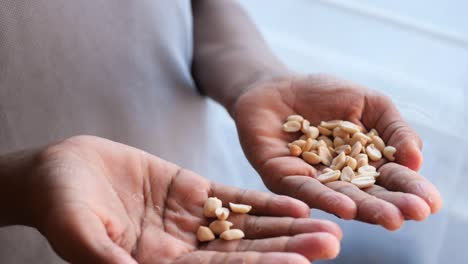 Men eating peeled peanuts close up