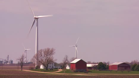 giant windmills generate power behind farms in the american midwest