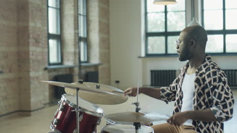 african american drummer playing drums in studio