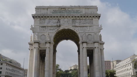 arco della vittoria in city of genoa, tilting up view with cloudy sky