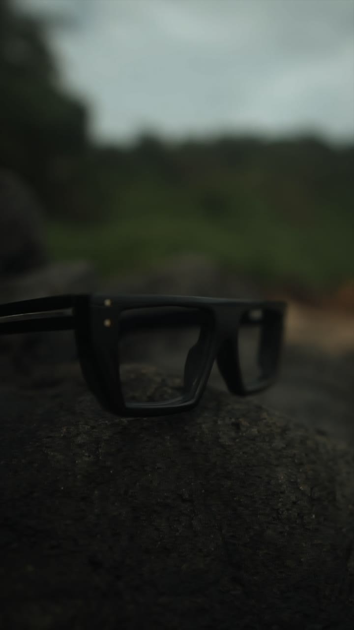 Glasses placed on a rock with a soft focus background, evoking calm and simplicity