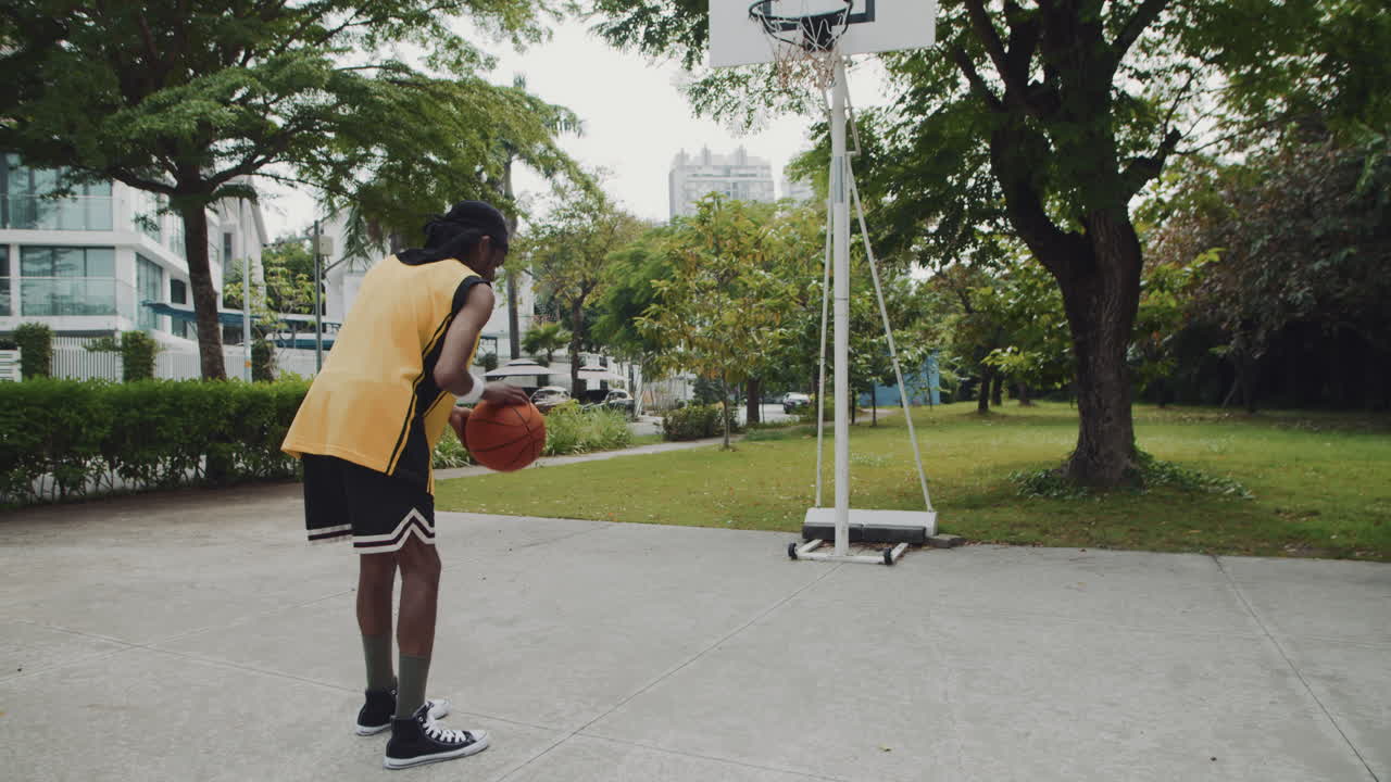 Black Sportsman Shooting Ball in Basket