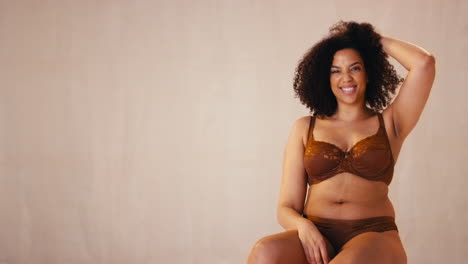 studio portrait shot of smiling confident natural woman in underwear promoting body positivity