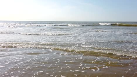 Beautiful-video-of-a-beach-from-the-coastline-during-sunset-while-the-waves-crash-the-shore,-Belgium