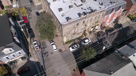 a rotating aerial establishing shot of an inner city apartment building on a street corner