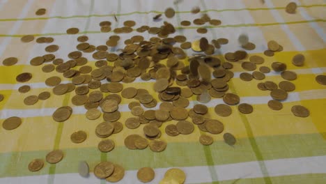 muchas monedas caen desde arriba sobre una cama amarilla y verde, cierran