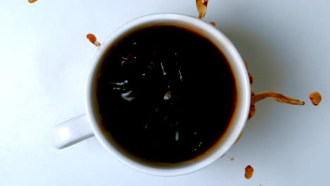 sugar cubes falling in cup of coffee