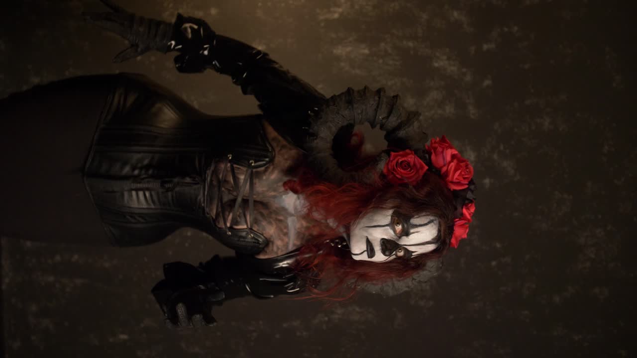 Catrina Cosplay girl reaching with her hands to the camera with Domina outfit and Dark background, Medium Close up