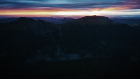magnificent aerial landscape of mountains at sunset with golden rays of light in the valley, 4k aerial view, auvergne, france.
