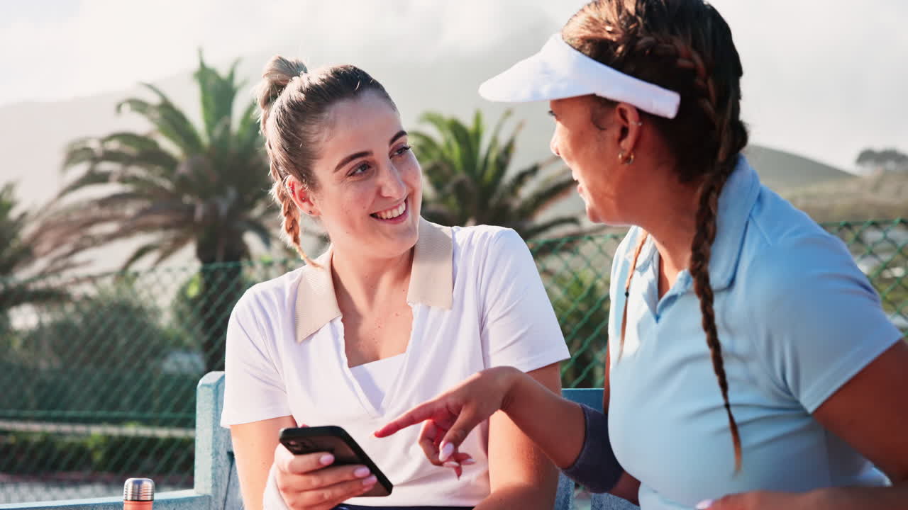 Two female tennis players chatting outdoors