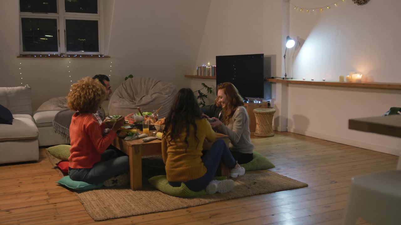 밀레니얼 세대의 성인 친구들이 집에서 함께 추수감사절을 기념하고 있습니다.