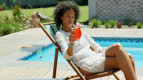 side view of young mixed frace woman relaxing on sun lounger in the backyard of home 4k