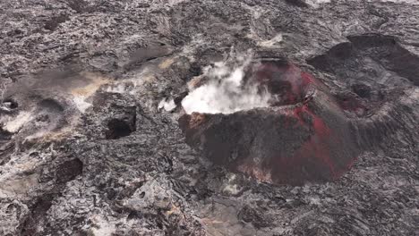drone view of volcanic crater in iceland with visible steam and red lava rocks, stunning aerial view of nature’s raw power