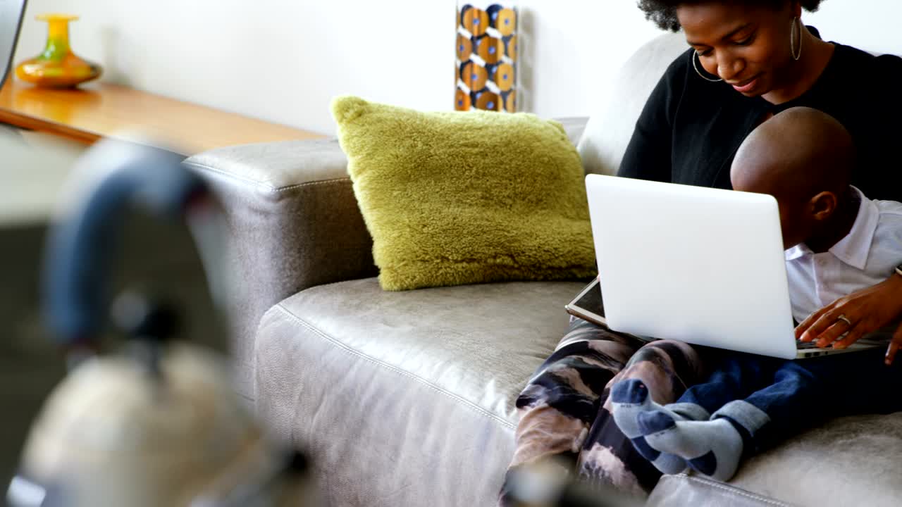 Mother and son using laptop in a comfortable home 4k