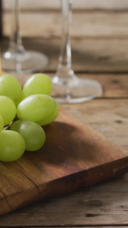 video of cheeses and grapes on board wine bottle and glasses on wooden table, with copy space