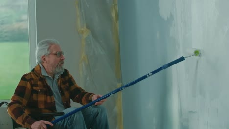 an elderly man in a wheelchair paints a wall with.mov | adult, age, apartment, blue