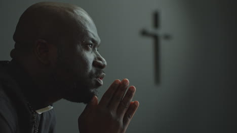 african american priest praying to god in church