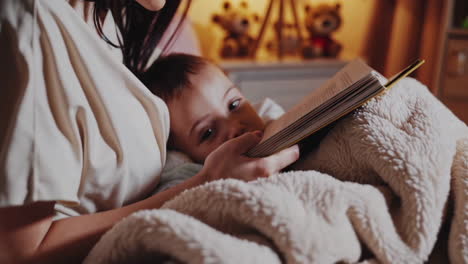 mother reading a book to baby