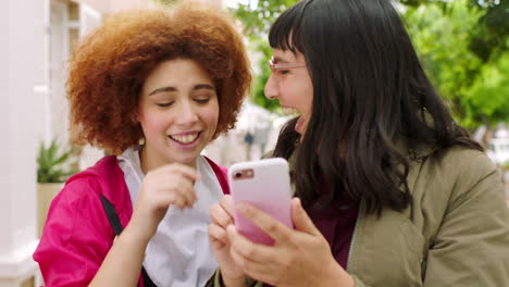 playful female friends taking selfies with a phone