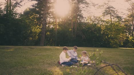 La-Niña-Ayuda-A-Los-Hermanos-A-Hacer-Tareas-En-El-Soleado-Jardín.