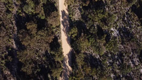 vista de los pájaros por encima de dos corredores de bicicletas de tierra compitiendo a lo largo de la pista de carretera
