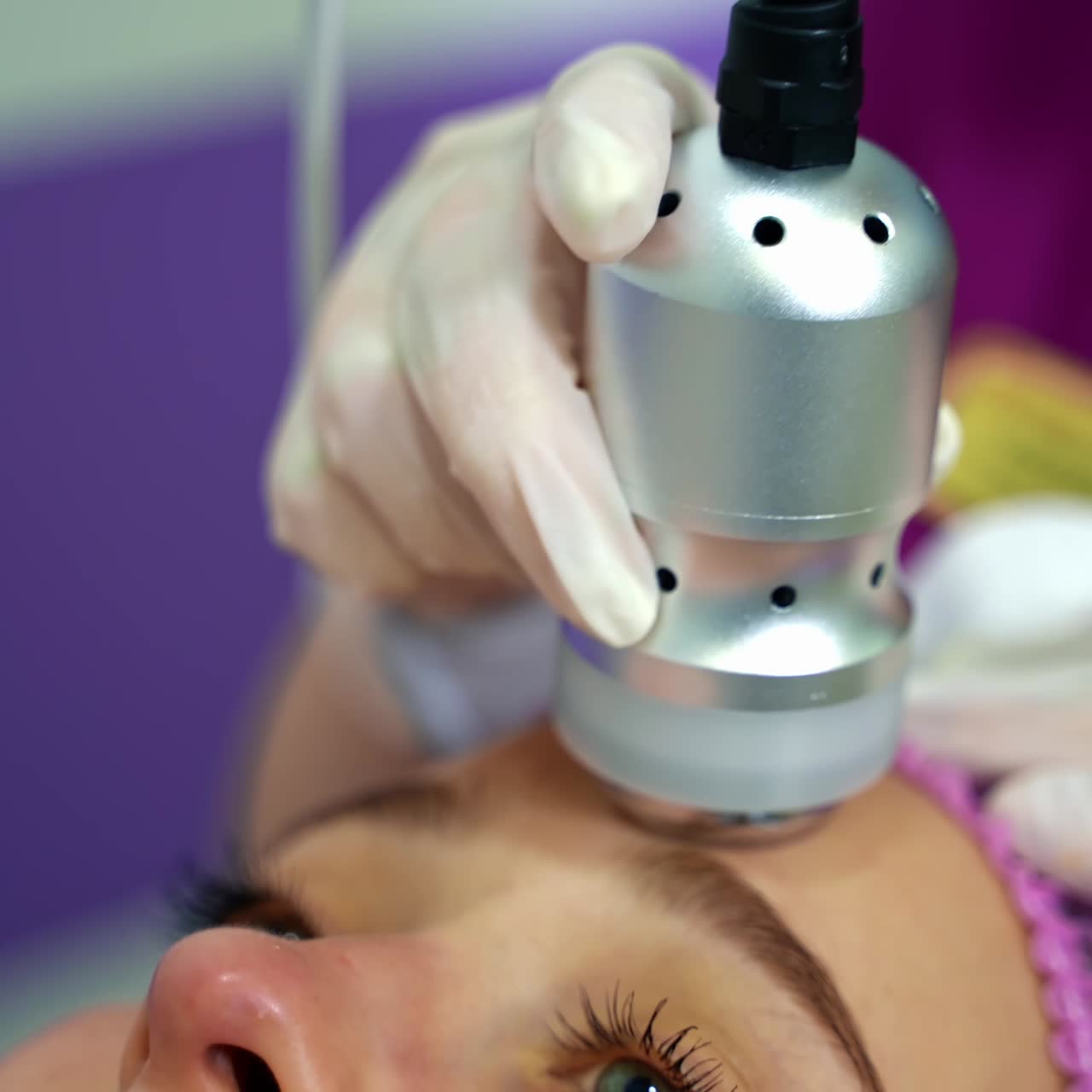 Lovely woman getting lifting treatment. Attractive girl receiving facial skin tightening procedure at beauty salon. Professional cosmetologist doing hardware skin treatment