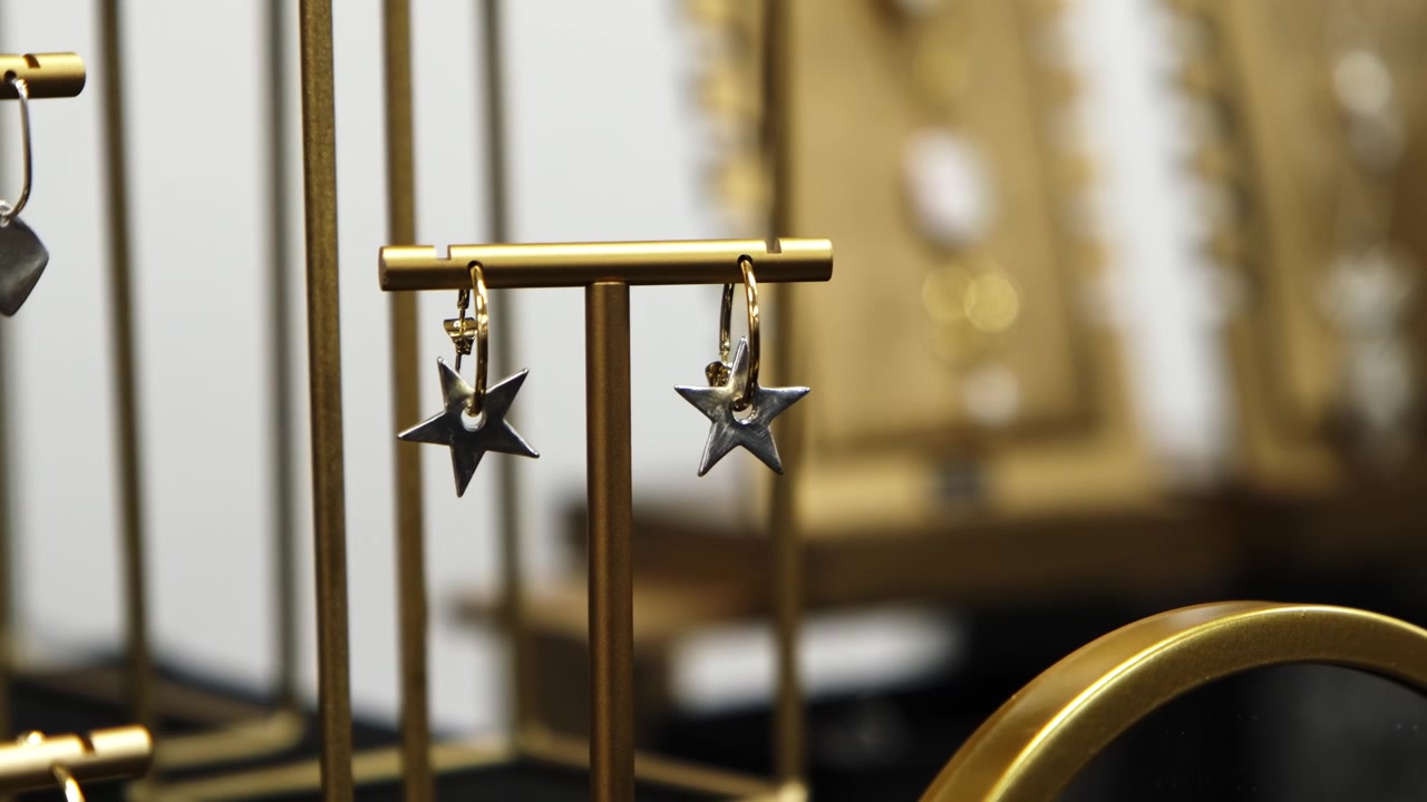 Primo piano di bellissimi orecchini pendenti a stella moderni in argento esposti su una bancarella del mercato