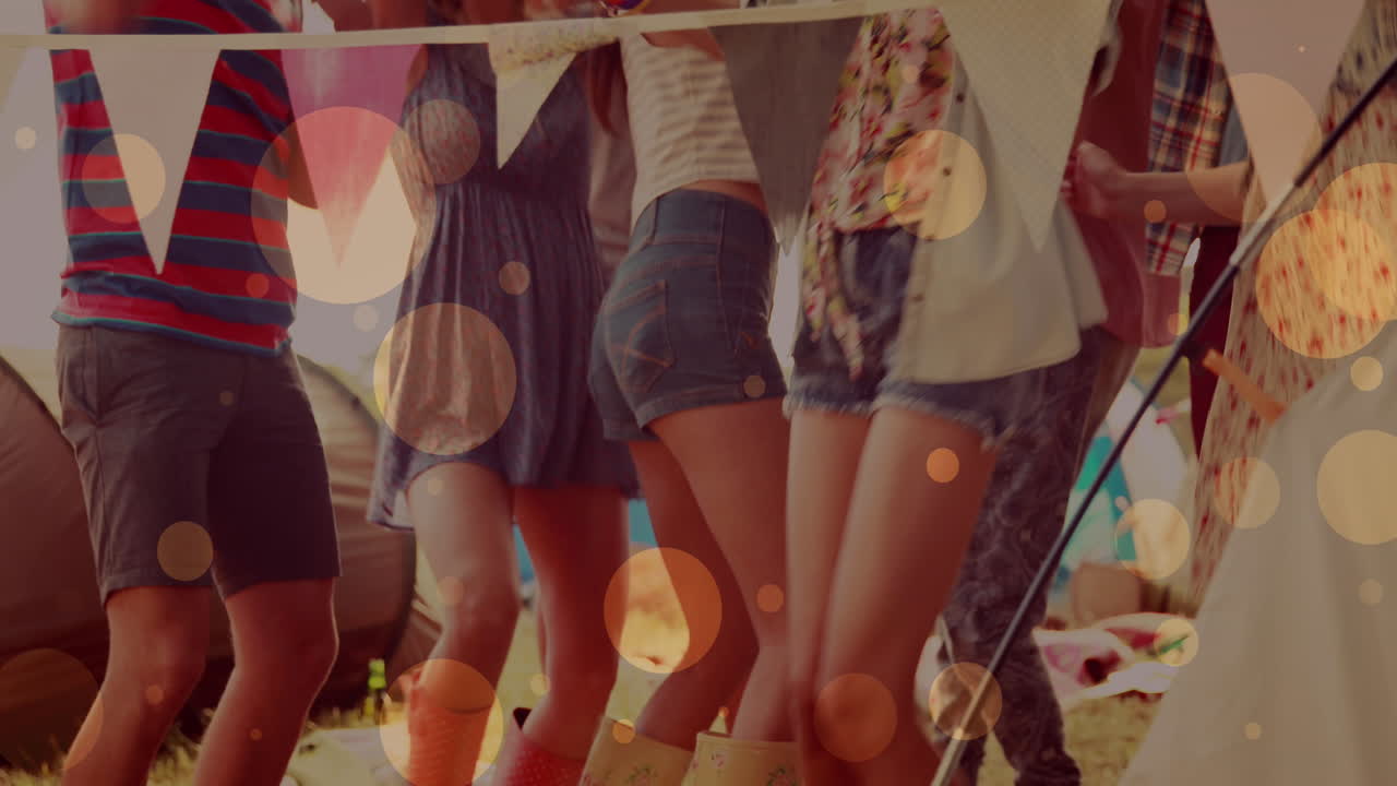 해변 파티에서 즐겁게 춤을 추는 친구들 위에 빛나는 노란색 불빛의 애니메이션