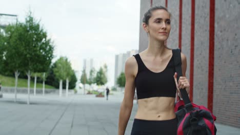 video de una mujer caminando en un traje de entrenamiento en la ciudad