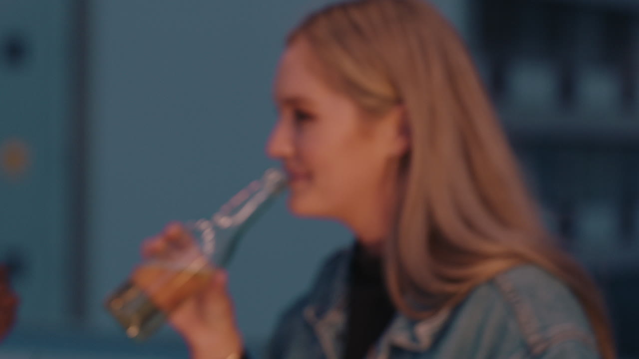 아름다운 젊은 여성 친구들이 토스트를 만들고 옥상 파티를 즐기고 술을 마시고 도시 저녁에 함께 춤을 추고 있습니다.