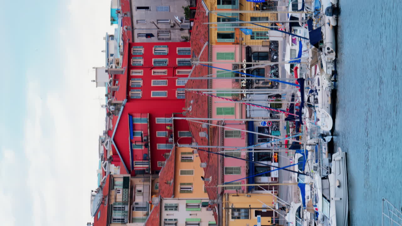 Nice, France - February 4, 2025: White boats docked in Port Lympia, overlooking the city. Vertical