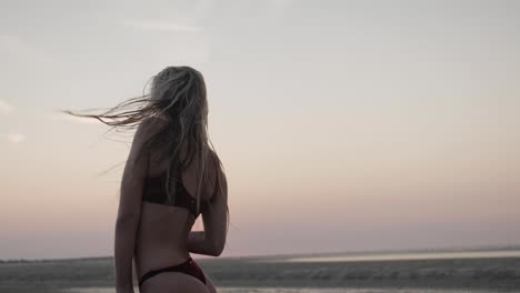 beautiful blonde model posing at the beach in a bikini set