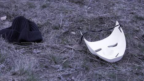 a lost mask and beanie in the grass