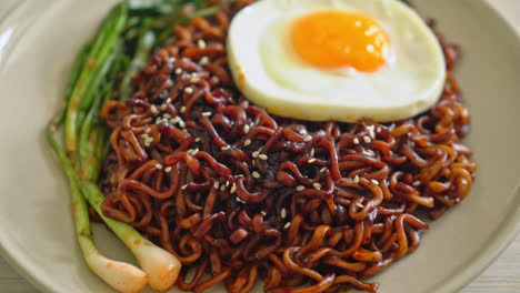 homemade dried korean spicy black sauce instant noodles with fried egg and kimchi