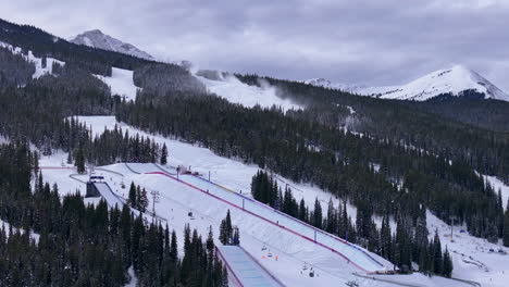 snow making half pipe big air jump ski snowboard gondola ski lift aerial drone cinematic copper mountain base colorado winter december christmas ski runs trails landscape rocky mountains zoom out