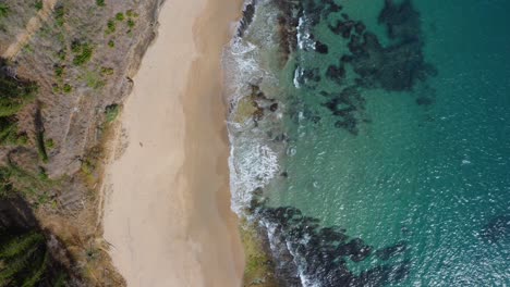 Beautiful-drone-shot-of-a-beach-and-the-transparent-sea-from-a-bird-eye-view