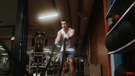 hombre trabajando con una cuerda en un gimnasio