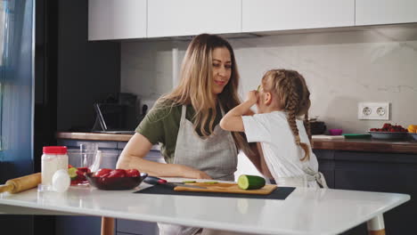 el niño juega con la madre joven en la cocina
