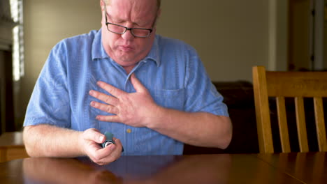 a mature man coughing and using an inhaler to clear lungs - static shot