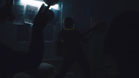 teenage boy performing in a dark bedroom