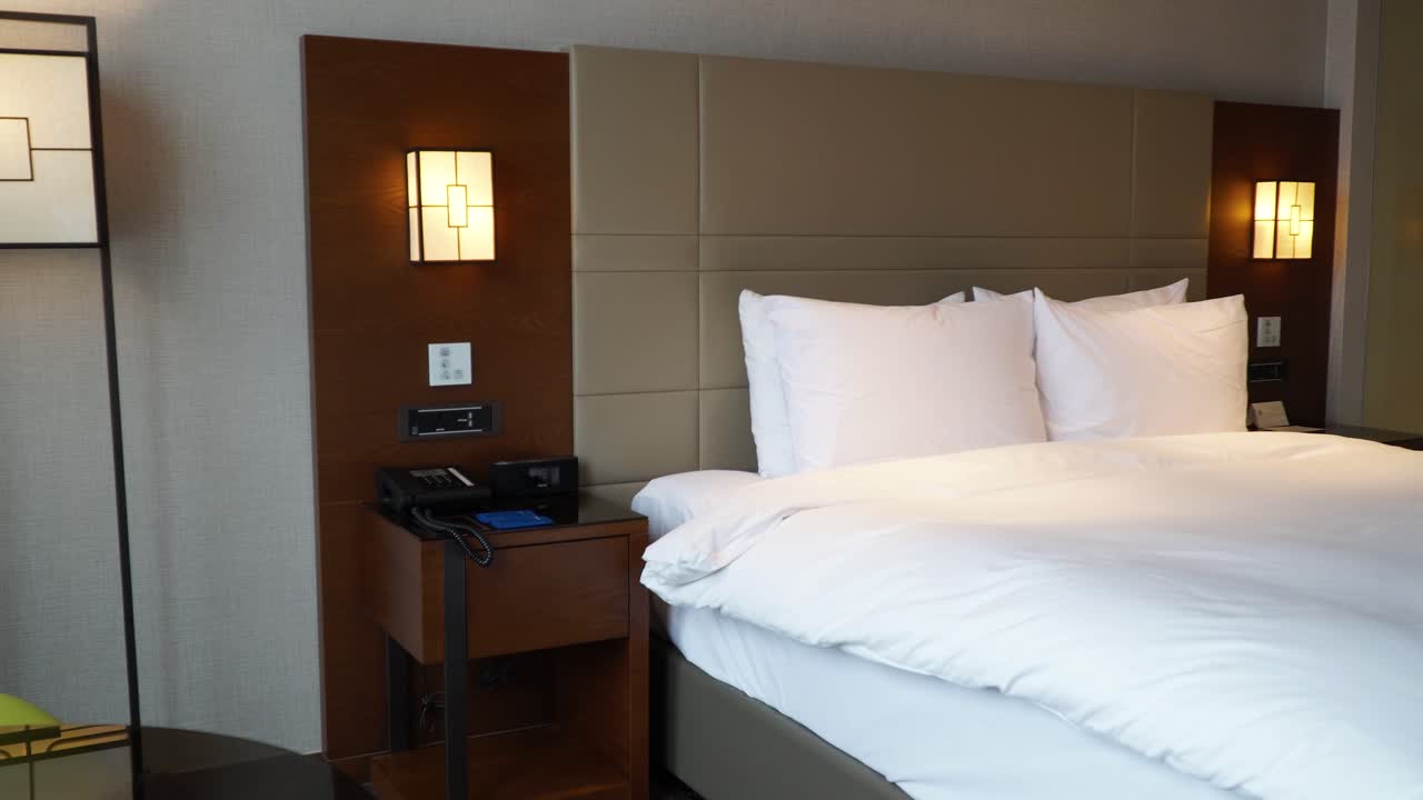 Panning left on made-up king size bed in Bussiness hotel room in Seoul, South Korea