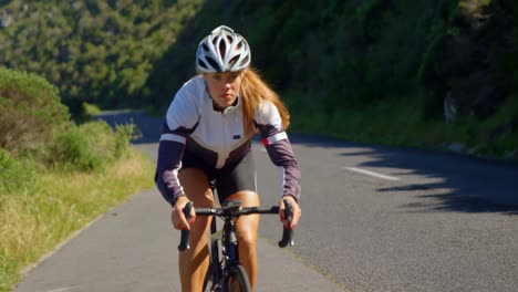 female cyclist cycling on a countryside road 4k