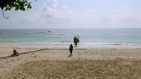 scuba diver walking towards boat arriving at diani beach in mombasa, kenya