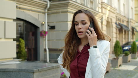 mujer de negocios enfocada hablando por teléfono móvil al aire libre