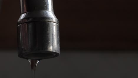 water turned on trickling out of kitchen sink tap before turned off and dripping slowly from metallic spout