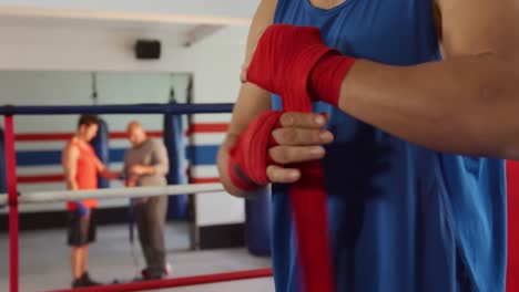 hombre de raza mixta envolviendo sus manos en el gimnasio