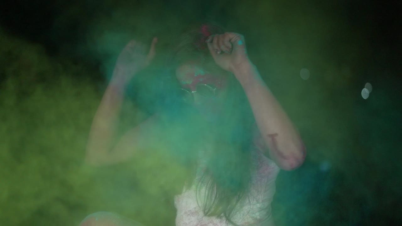 joven india bailando con polvo de color seco holi explotando a su alrededor