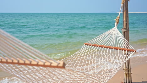 empty hammock on exotic beach. focus on foreground